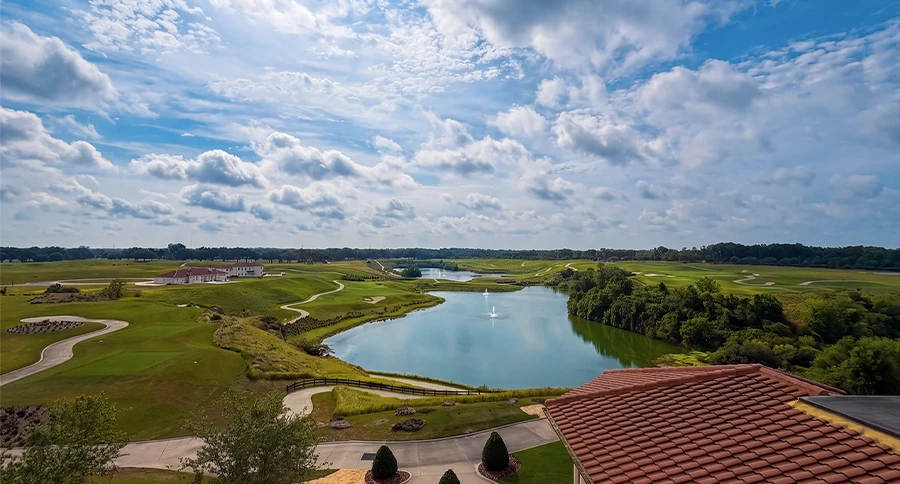 Panoramic view of the IronCrest golf course, quarry lakes, rolling terrain, and The Club at Iron Lake clubhouse in Ocala, Florida.