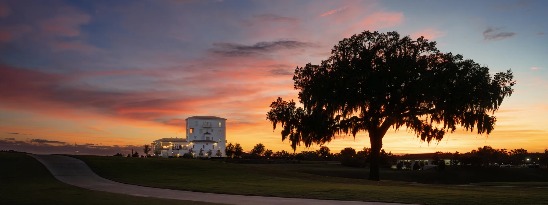 Sunset view of The Club at Iron Lake overlooking championship golf and ancient oak trees at IronCrest.