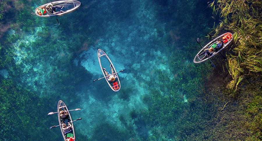 Aerial view of paddlers exploring crystal-clear spring water near Ocala, Florida.